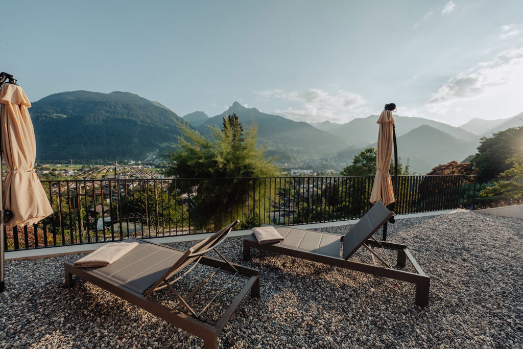 sonniger Sommertag auf Terrasse mit Liegestühlen und mit Ausblick auf Schruns und die Berge
